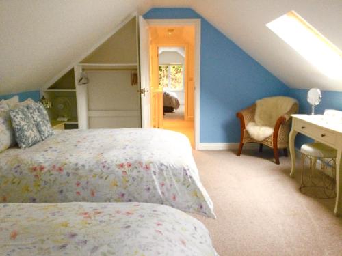 a bedroom with a bed and a desk in a attic at Y Bwthyn in Bangor