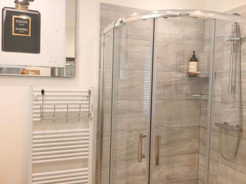 een douche met een glazen deur in de badkamer bij Y Bwthyn in Bangor