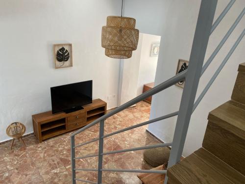 a living room with a television and a staircase at Casa Carmen by VG in Maro
