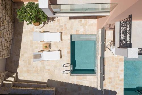 um prédio com piscina e janela em Onore Luxury Suites em Kato Korakiana