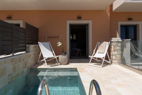 a pair of chairs sitting on a patio next to a pool at Onore Luxury Suites in Kato Korakiana