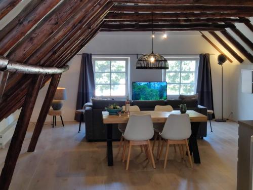 una sala da pranzo e un soggiorno con tavolo e sedie. di Appartement Badnieuweschans a Bad Nieuweschans