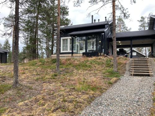 a house on a hill with trees in front of it at Ylläs Fell Inn in Äkäslompolo