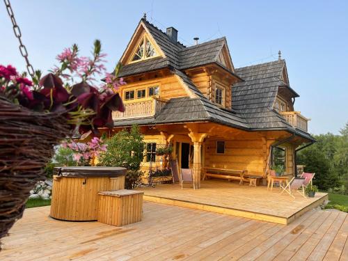 une cabane en rondins avec un toit sur une terrasse en bois dans l'établissement DOM Krzeptówki 133, à Zakopane