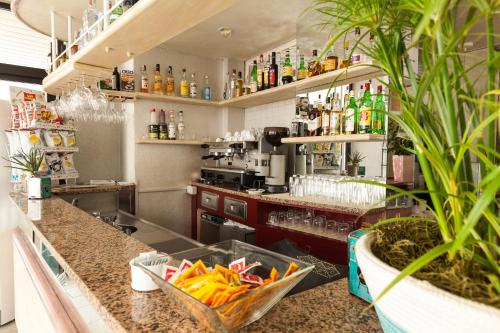 a kitchen with a counter with drinks on shelves at Hotel al Nuovo Porto in Bellaria-Igea Marina