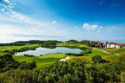 バルチクにあるLighthouse 3 bedrooms villa F36の湖のあるゴルフコースの景色を望めます。