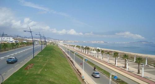 a road with cars driving on it next to a beach at La Vida Villa Alcudia Smir Fnideq, Holiday Homes in Tetouan