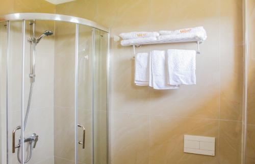 a bathroom with a shower and white towels at Shkreli Resort Qafeshtame in Krujë