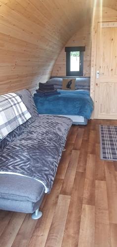 una camera con letti in una cabina di legno di The Pod at Hollingwell House - Glamping NC500 Edderton a Balblair