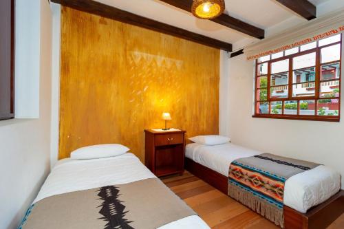 a bedroom with two beds and a window at Acoma in Otavalo