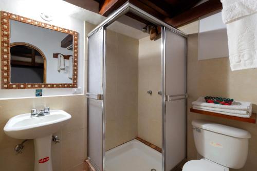 a bathroom with a shower and a toilet and a sink at Acoma in Otavalo