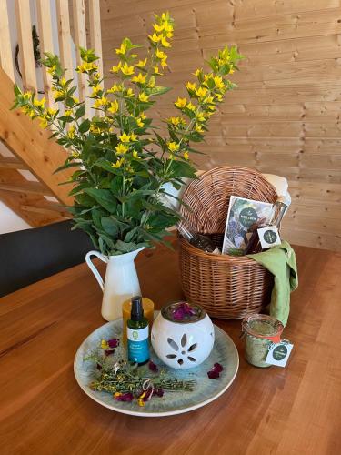 a table with a vase and a bouquet of flowers at Wildkräuter Hexenhaus in Mauth