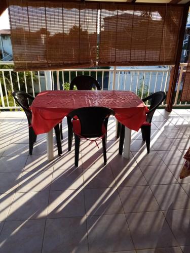 a red table and two chairs on a deck at logement aux saveurs des mangues juli in Baillif