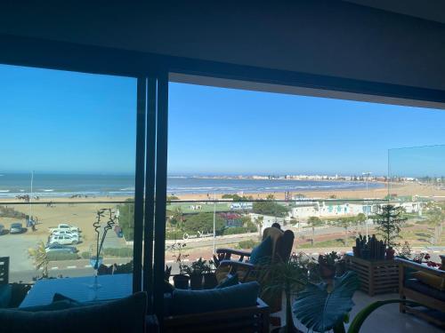 a living room with large windows looking out at the ocean at PRESTIGIA ESSAOUIRA MOGADOR Luxury Ocean View in Essaouira