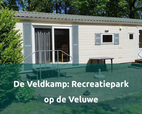 a backyard retreat with a table and a house at Chalet 4-6 Personen Epe F15 Van alle gemakken voorzien Max aantal volwassen personen bedraagt 4 in Epe