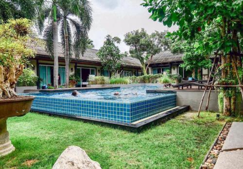 a swimming pool in the yard of a house at Nirundorn Resort Chaam in Cha Am