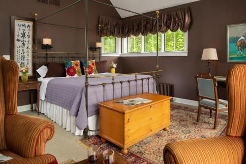 a bedroom with a bed and a desk and chairs at Ashby Inn & Restaurant in Paris