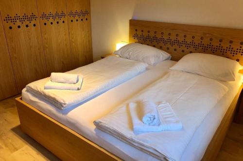 1 dormitorio con 2 camas y toallas. en Vila Slavc, cosy apartment near the lake en Bled