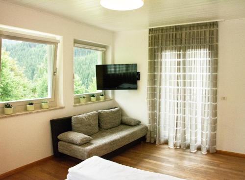 un soggiorno con divano e TV a schermo piatto di Villa Gottfried Appartment a Ega
