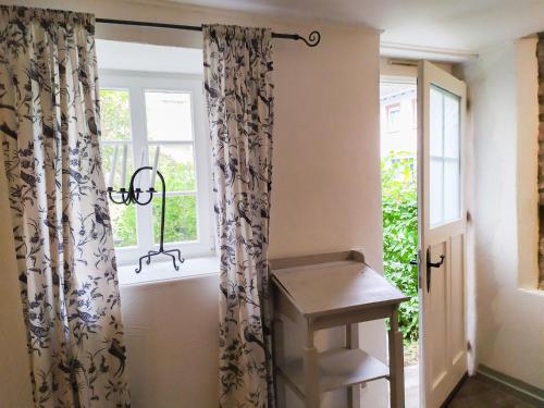 a room with curtains and a stool next to a window at Living-in-History: Meister Carl Apartment in Dudeldorf