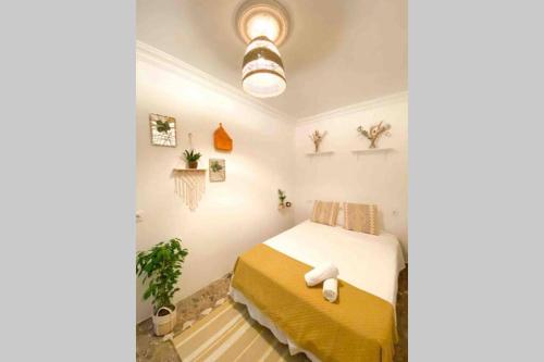 een slaapkamer met een bed in een kamer met planten bij Agradable casa de campo con piscina en la Barrosa in Chiclana de la Frontera