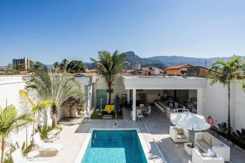 una vista di una casa con piscina di Casa com área gourmet e piscina na praia do Indaiá a Caraguatatuba