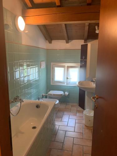 a bathroom with a tub and a toilet at Villa Canapa in Campogalliano