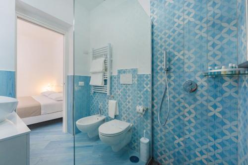 a blue bathroom with a toilet and a shower at Poseidonia Rooms in Procida