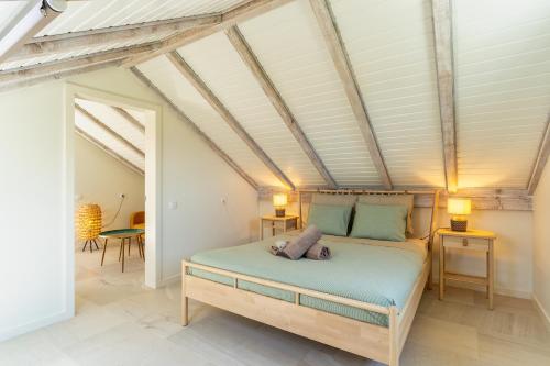 een slaapkamer met een bed in een kamer met zichtbare plafonds bij Villa Horizonte Azul by Holiday Rental Madeira in Ponta do Sol