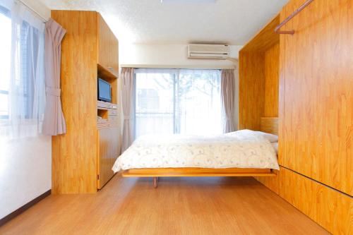 Habitación pequeña con cama y ventana en FLEXSTAY INN Nakanobu en Tokio