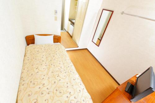a small room with a bed and a television at FLEXSTAY INN Nakanobu in Tokyo