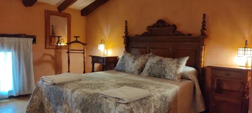 a bedroom with a large bed with two towels on it at Hotel Rural el Arrabal Siguenza in Sigüenza