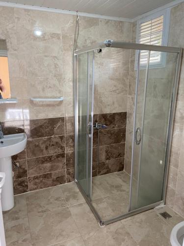 La salle de bains est pourvue d'une douche avec une porte en verre. dans l'établissement Lombane Apart, à Rize