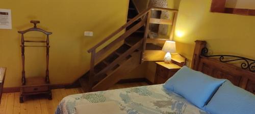 a bedroom with a bed and a wooden staircase at Hotel Rural el Arrabal Siguenza in Sigüenza