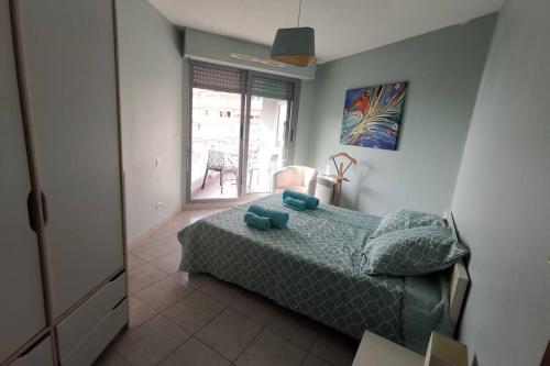 une chambre avec un lit avec des oreillers bleus dans l'établissement Appartement 6 personnes face à la mer, à Cagnes-sur-Mer