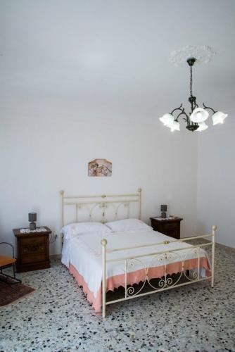 a bedroom with a bed and a chandelier at La casetta di Anna in Palazzolo Acreide