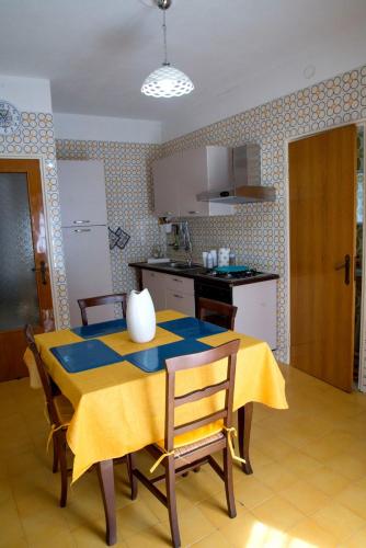 a kitchen with a table with a yellow table cloth at La casetta di Anna in Palazzolo Acreide
