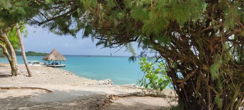 a view of a beach with a boat in the water at Casa Aventureros Isla Grande Colombia in Cartagena de Indias
