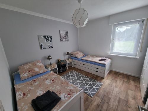 a bedroom with two beds and a window at Ferienhaus mit Ausblick in Brilon