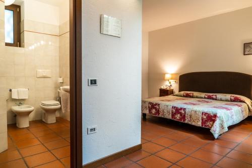 a bathroom with a bed and a toilet in a room at La Corte di Lurago in Lurago D'Erba 