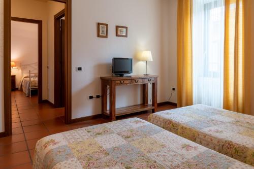 a hotel room with two beds and a television at La Corte di Lurago in Lurago D'Erba 