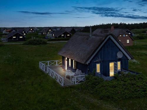 a small house with a deck in a field at 4 person holiday home in Harbo re in Harboør