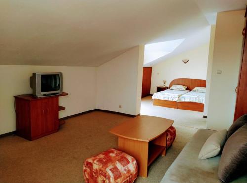 a living room with a television and a bed at Solis in Primorsko