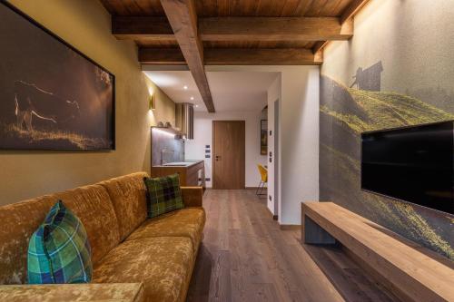 a living room with a couch and a flat screen tv at Cima Dodici B&B - Apartments in Sesto