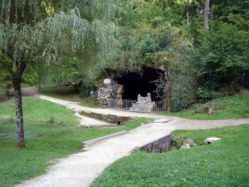 a entrance to a cave in a park with a path at La Malinette B&B, calme et authenticité in Mâlain