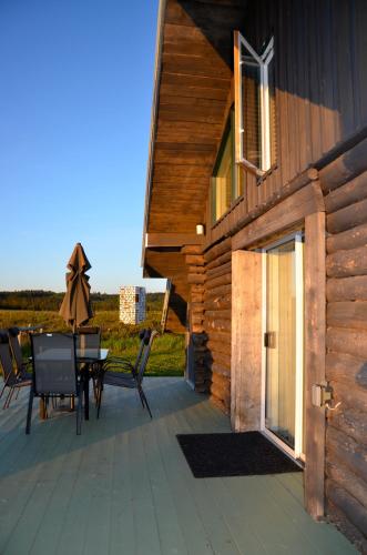 a wooden deck with a table and chairs on a house at Woodhouse Cottages And Ranch in Prince George