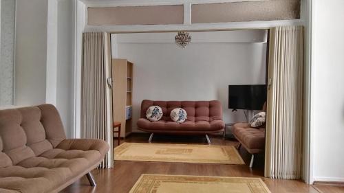 een woonkamer met 2 banken en een spiegel bij Uysal Suite and Loft Seaside in Marmaris