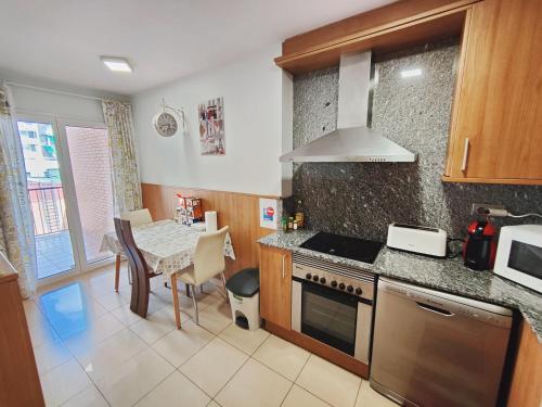 a kitchen with a table and a stove top oven at Agora Apartments in Lleida