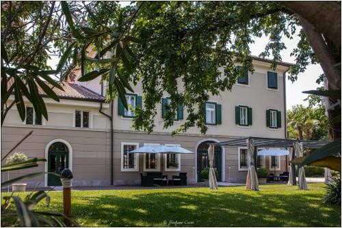 un grande edificio con tavolo e ombrellone all'aperto di Villa Rigatti a San Valentino