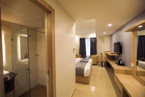 a hotel room with a bed and a bathroom at PP Residency in Covelong